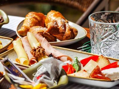 Différents plats et un verre d'eau sur une table à manger en plein air.