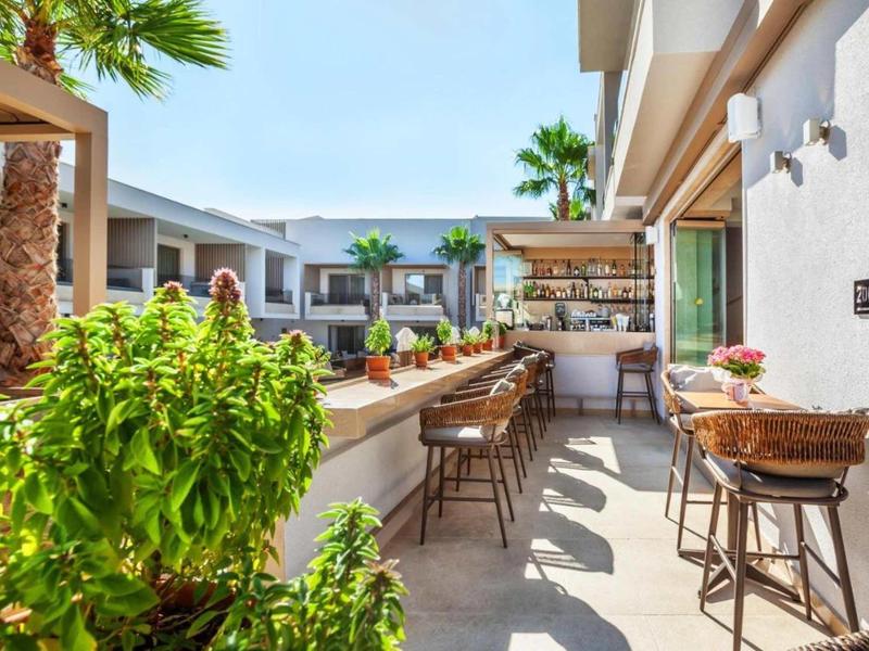 Strefa baru zewnętrznego z hokerami, roślinami i nowoczesnym designem pod czystym niebem.