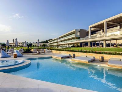 Moderner Hotelpool mit Liegen und Sonnenschirmen bei klarem Himmel