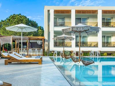 Modern hotel pool with lounge chairs, umbrellas, and a building in the background