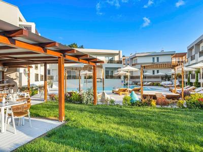 Modern hotel outdoor area with pool and seating on a sunny day.