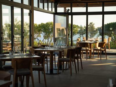 Modern restaurant met grote ramen met uitzicht op water en bomen