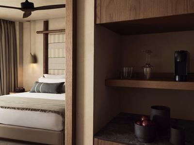 Modern eingerichtetes Hotelzimmer mit gemütlichem Bett und Kaffeezubereitungsecke.