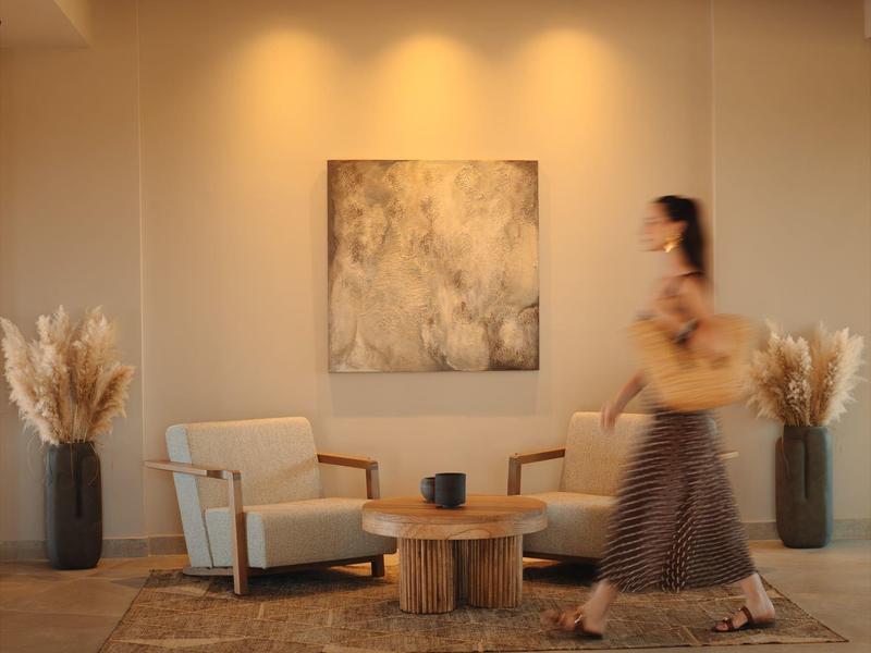 Moderne leeshoek met twee fauteuils, houten tafel en decoratie in een hotelkamer.