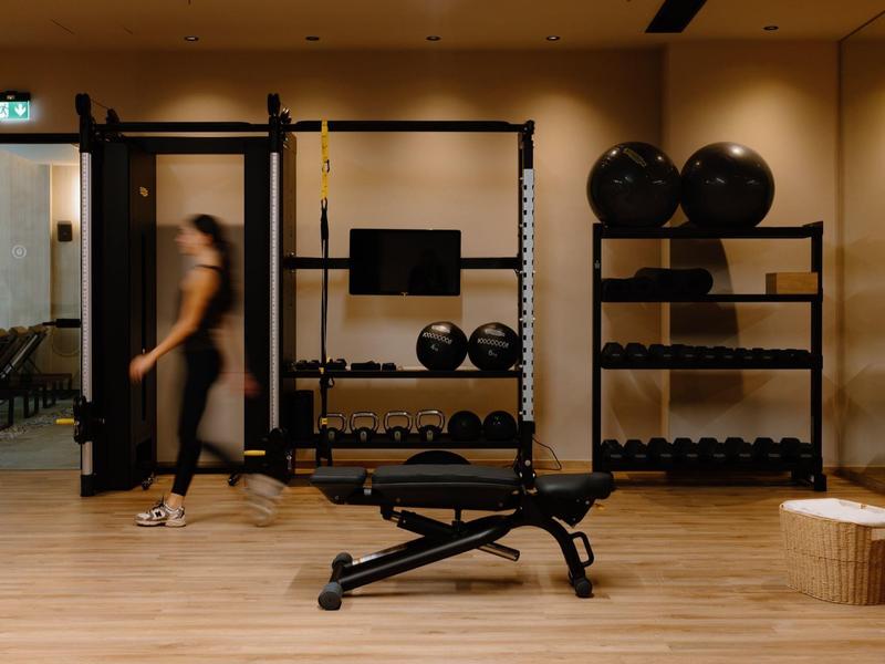 Moderne Fitnessfläche mit Hanteln, Gymnastikbällen und einer Trainingsbank.