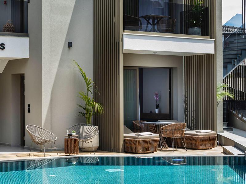 Nowoczesny basen hotelowy z wygodnymi miejscami do siedzenia i eleganckimi drewnianymi wykończeniami.