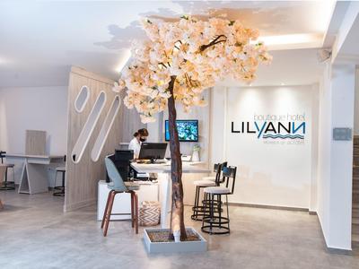 Moderner Salon mit rosa blühendem Baum, weißen Wänden und minimalistischen Friseurstühlen.