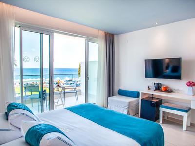 Hell eingerichtetes Hotelzimmer mit Meerblick und Balkon