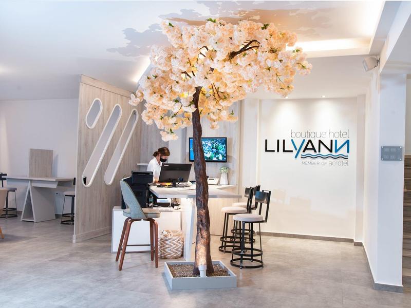 Moderner Salon mit rosa blühendem Baum, weißen Wänden und minimalistischen Friseurstühlen.