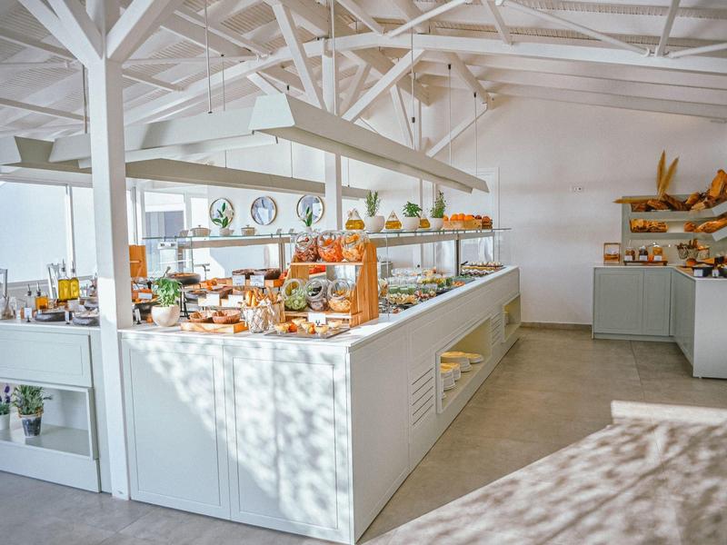 Helle Bäckerei mit modernen weißen Regalen und vielfältigem Brot- und Gebäckangebot.