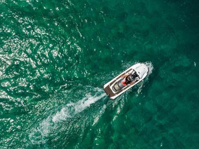 Boot fährt über das grüne Wasser des Meeres und hinterlässt eine weiße Spur
