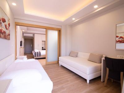 Moderner Wohnraum mit zwei weißen Sofas, hellem Holzboden, Wandleuchten und minimaler Dekoration.