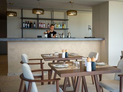 Modern hotel bar area with counter and cozy seating.