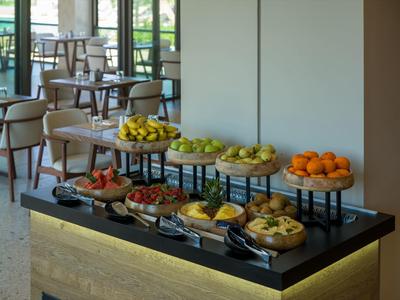 A buffet with various fresh fruits in a bright restaurant area.