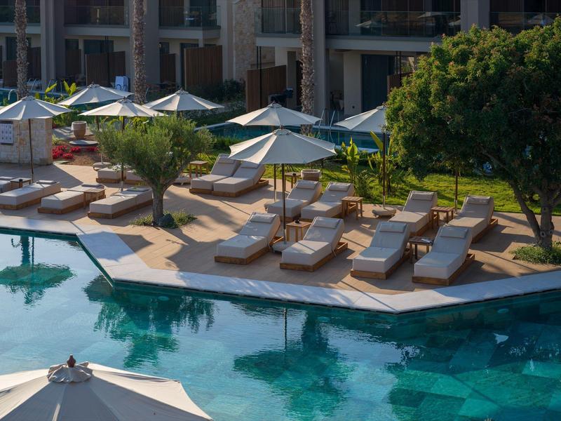 Pool area with sun loungers and umbrellas in a hotel garden