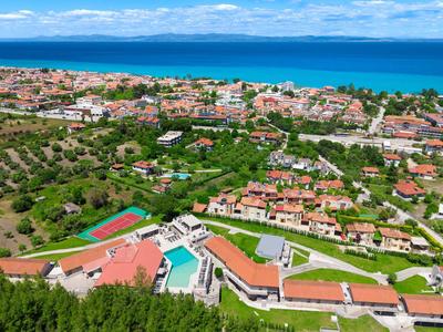 Widok panoramiczy hotelu z basenami blisko nadmorskiego miasta.