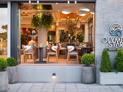 Modernes Café mit Holzstühlen, grünen Pflanzen und großem Fensterfront in modernem Gebäude.