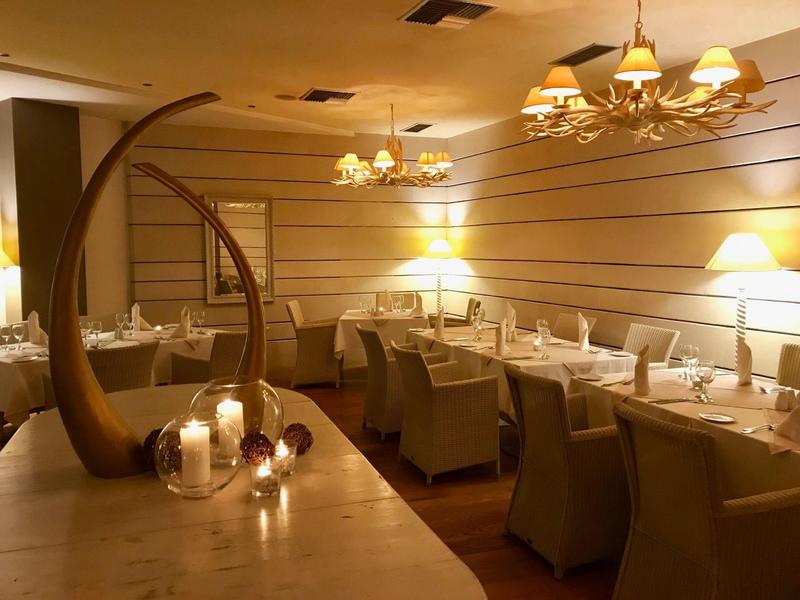 Cozy hotel restaurant with elegant tables, soft lighting, and decorative candles.