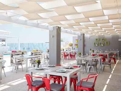 Helle, moderne Außenterrasse mit weißen Tischen und roten Stühlen in einem Restaurant.