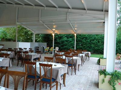 Überdachte Außenterrasse eines Hotels mit gedeckten Tischen und Stühlen