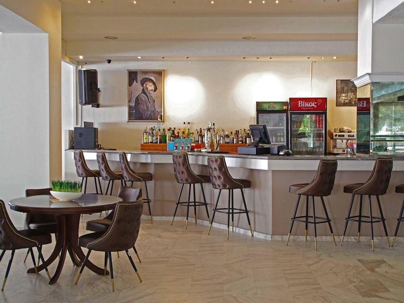 Moderner Barbereich mit Hockern und Sitzgelegenheiten in einem Hotel.