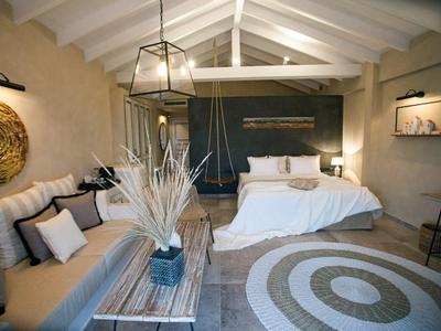 Modern eingerichtetes Schlafzimmer mit weißem Bett und runder Teppich auf dem Boden