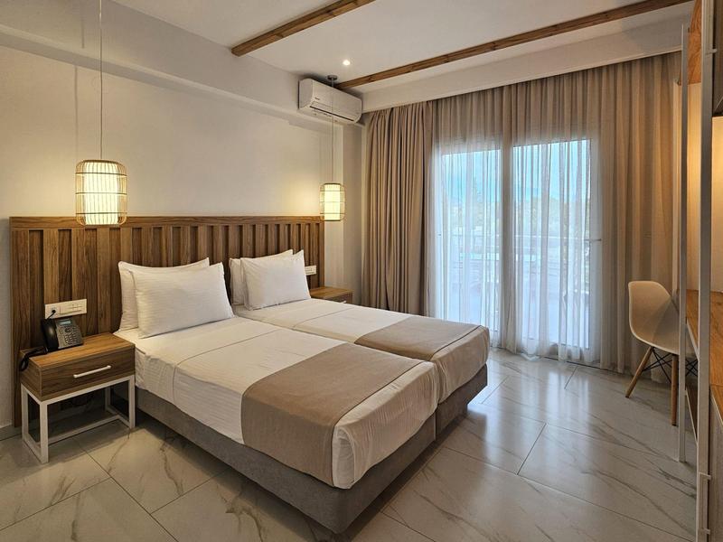 Modernes Hotelzimmer mit zwei Betten, Holzverkleidung, großen Fenstern und neutralen Farben.