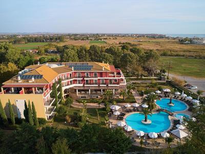 Gran hotel con dos piscinas redondas y tumbonas en un entorno rural.