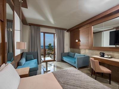 Nowoczesny pokój hotelowy z dwoma sofami i balkonem z widokiem na morze.