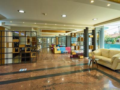 Spaziosa hall dell'hotel con aree salotto, arredamento moderno e grandi finestre.