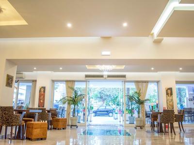 Heller Hotel-Lobbybereich mit modernem Mobiliar und großen Fenstern zum Außenbereich.