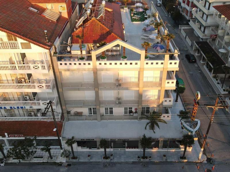 Letecký pohled na ulici se budovami a zaparkovanými auty za teplého slunečního světla.