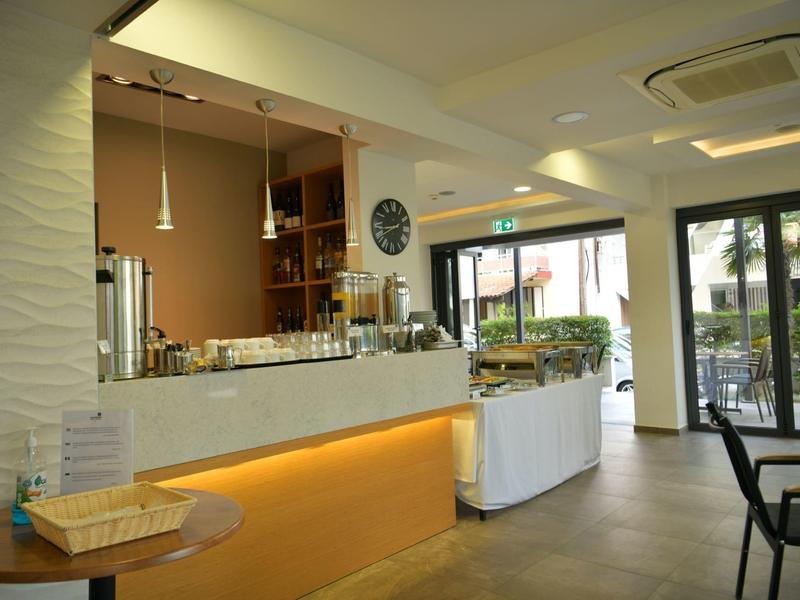 Lichte ontbijtruimte met buffet, grote ramen en modern design.