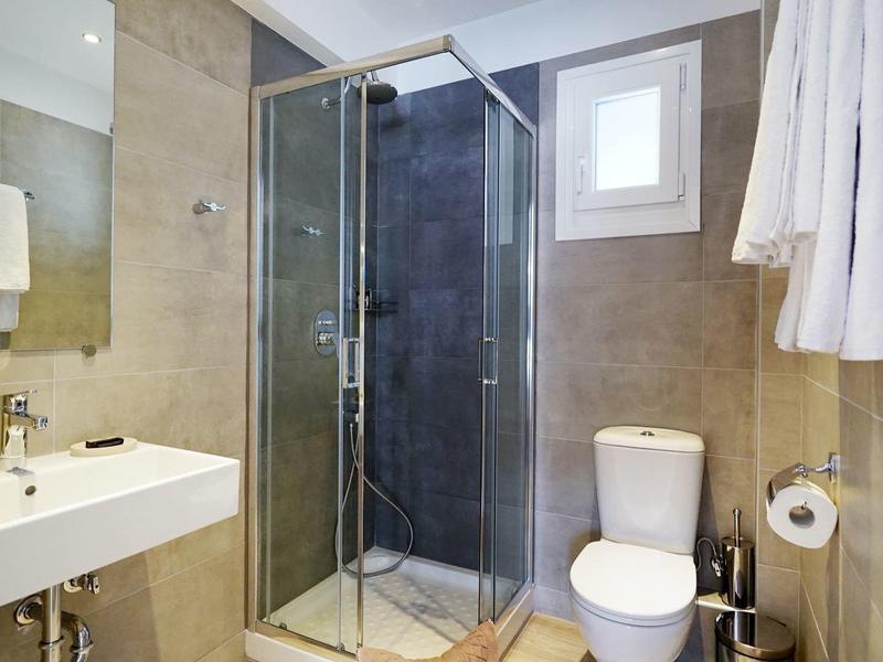 Moderne badkamer met douche, toilet en wastafel in neutrale tinten.