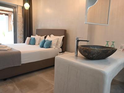 Habitación de hotel moderna con cama doble, almohadas y lavabo integrado en primer plano.