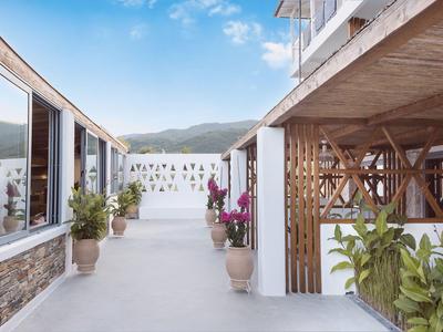 Couloir d'hôtel moderne avec plantes et vue sur les montagnes sous un ciel bleu
