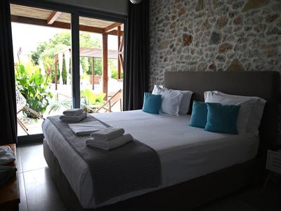 Acogedor dormitorio con cama grande, cojines azules y vista a una terraza.