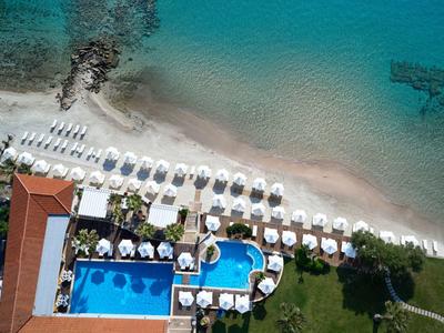 Widok z lotu ptaka na plażę z leżakami i dwoma basenami obok hotelu