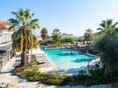 Hotelpool mit Liegestühlen, Palmen und sonnigem Himmel