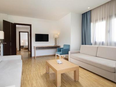 Soggiorno moderno con due divani, un piccolo tavolo in legno e una TV a schermo piatto sulla parete.