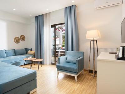 Soggiorno moderno con mobili blu, pavimento in legno e accesso al balcone.