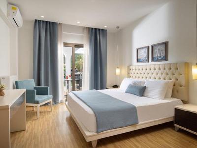 Camera d'hotel arredata modernamente con letto matrimoniale, tende blu e balcone