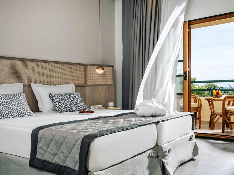 Nowoczesny pokój hotelowy z łóżkiem podwójnym i balkonem z widokiem na morze