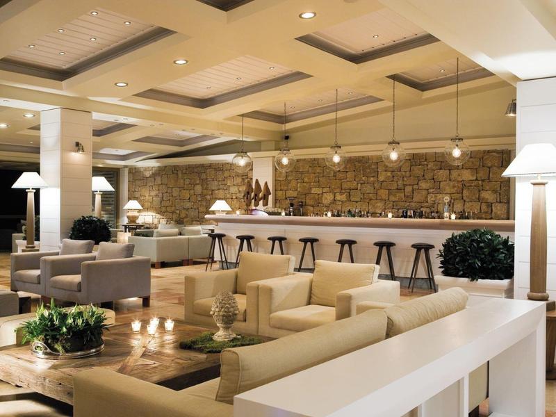 Moderní hotelový bar s pohodlnými křesly, barovými židlemi a útulnou atmosférou.