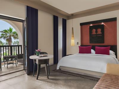 Modernes Hotelzimmer mit großem Bett, Balkon und Meerblick.