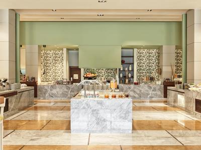 Ein heller Spa-Bereich mit Marmor, Holzfußboden, grüner Wand und dekorativen Elementen.