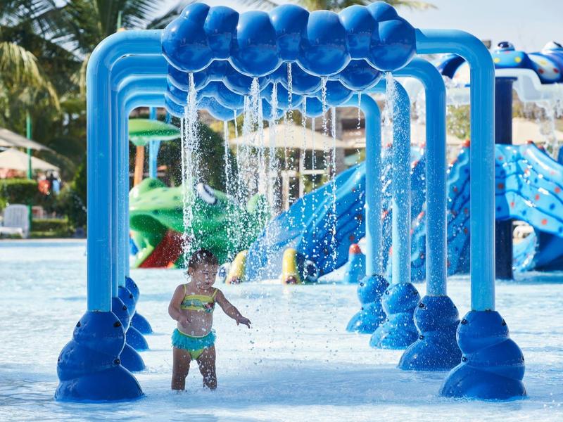 Heller, moderner Eingangsbereich mit stilvollem Mosaik, blauen Kugelleuchten und elegantem Wasserbecken.