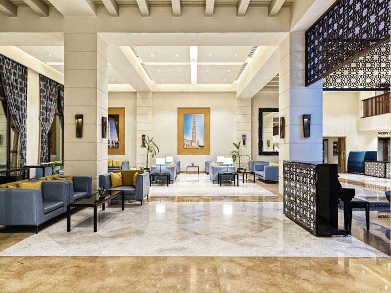 Großer, heller Lounge-Bereich mit Marmorfußboden, modernen Sesseln und dekorativen Trennwänden.