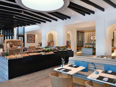 Modern restaurant with elegantly set tables and buffet area in a bright setting.