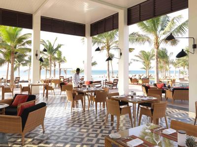 Open dining area with wooden furniture and sea view through large windows.